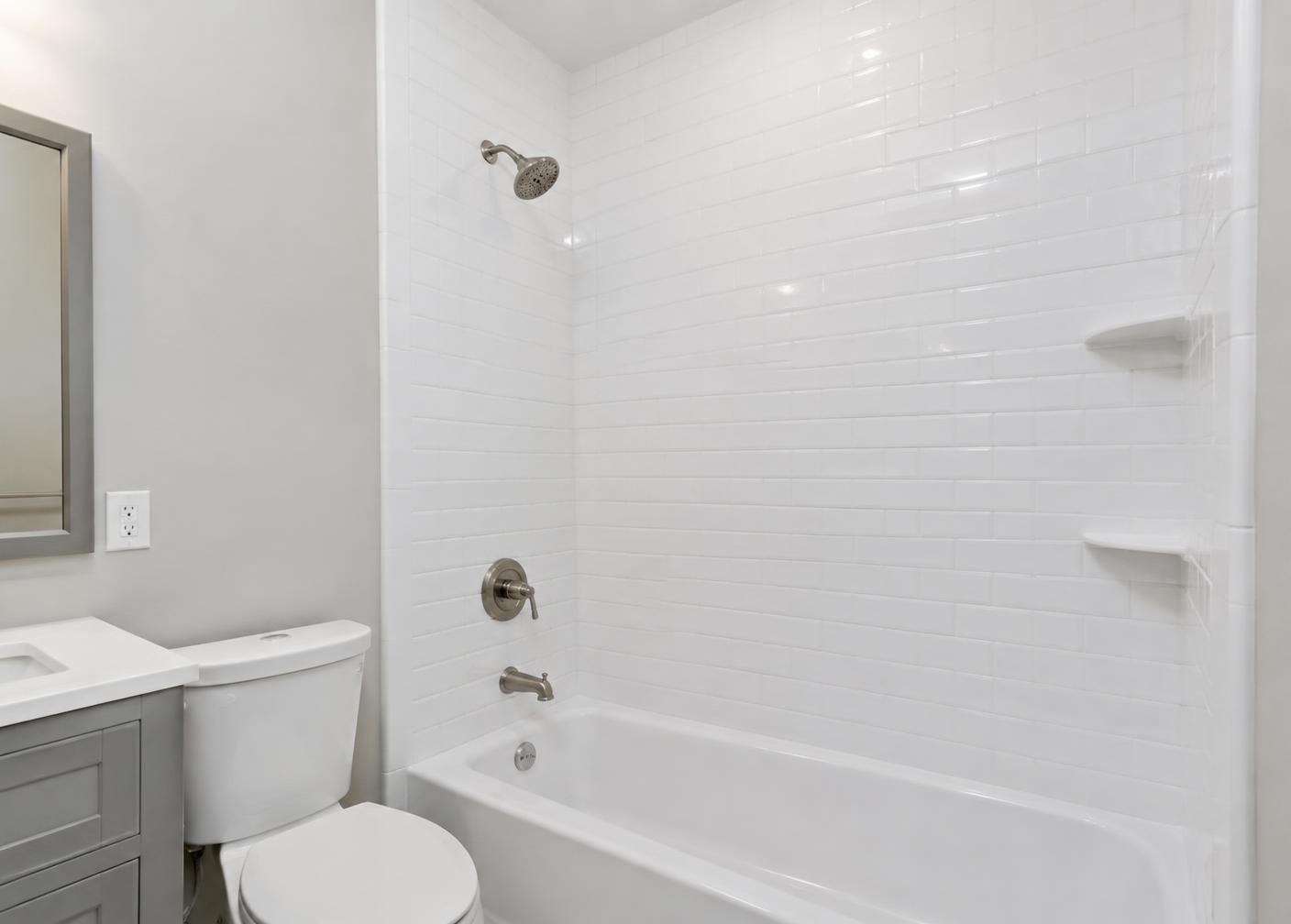 Refinished tub and tile surround in a renovated apartment bathroom